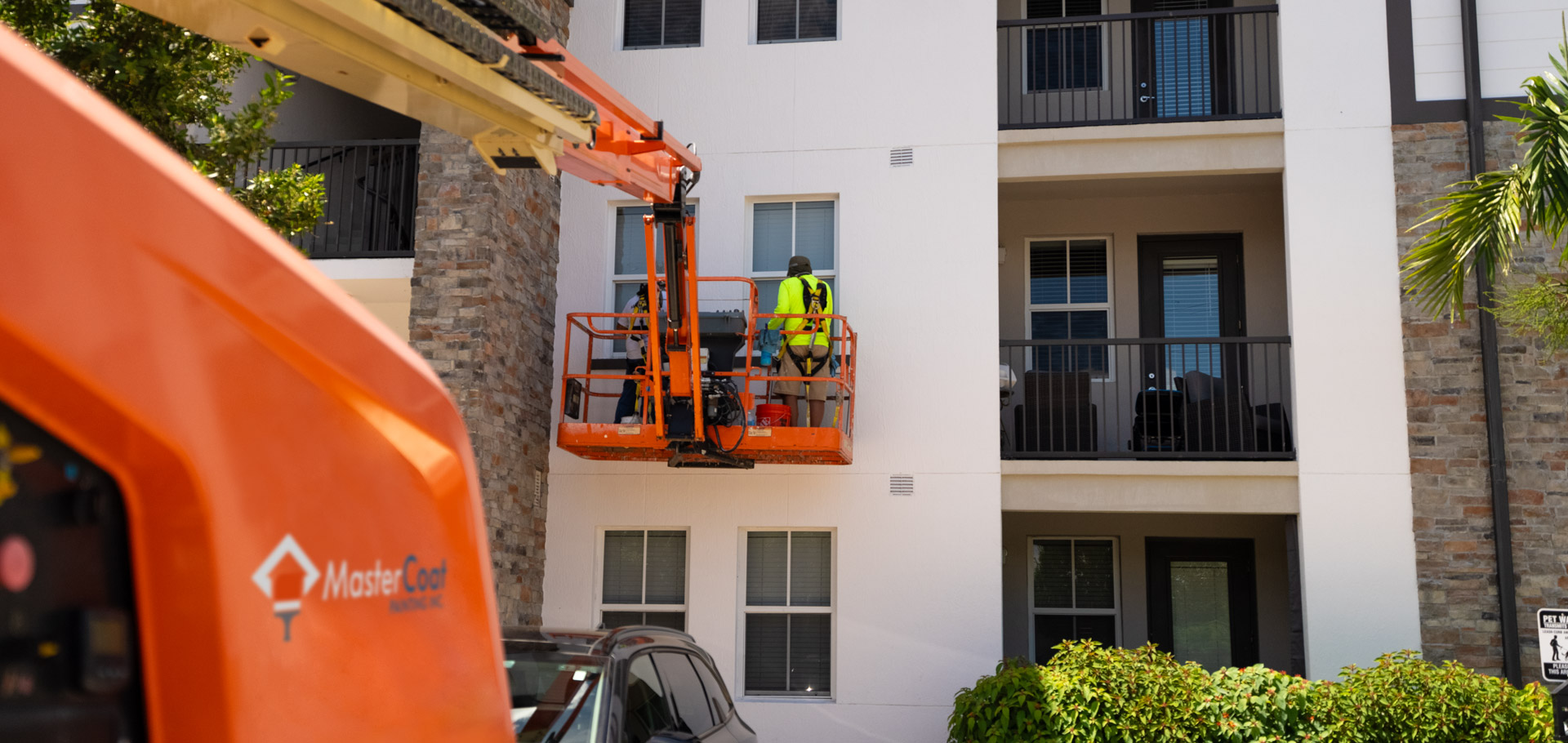painters in a lift, painting a building in Fort Myers